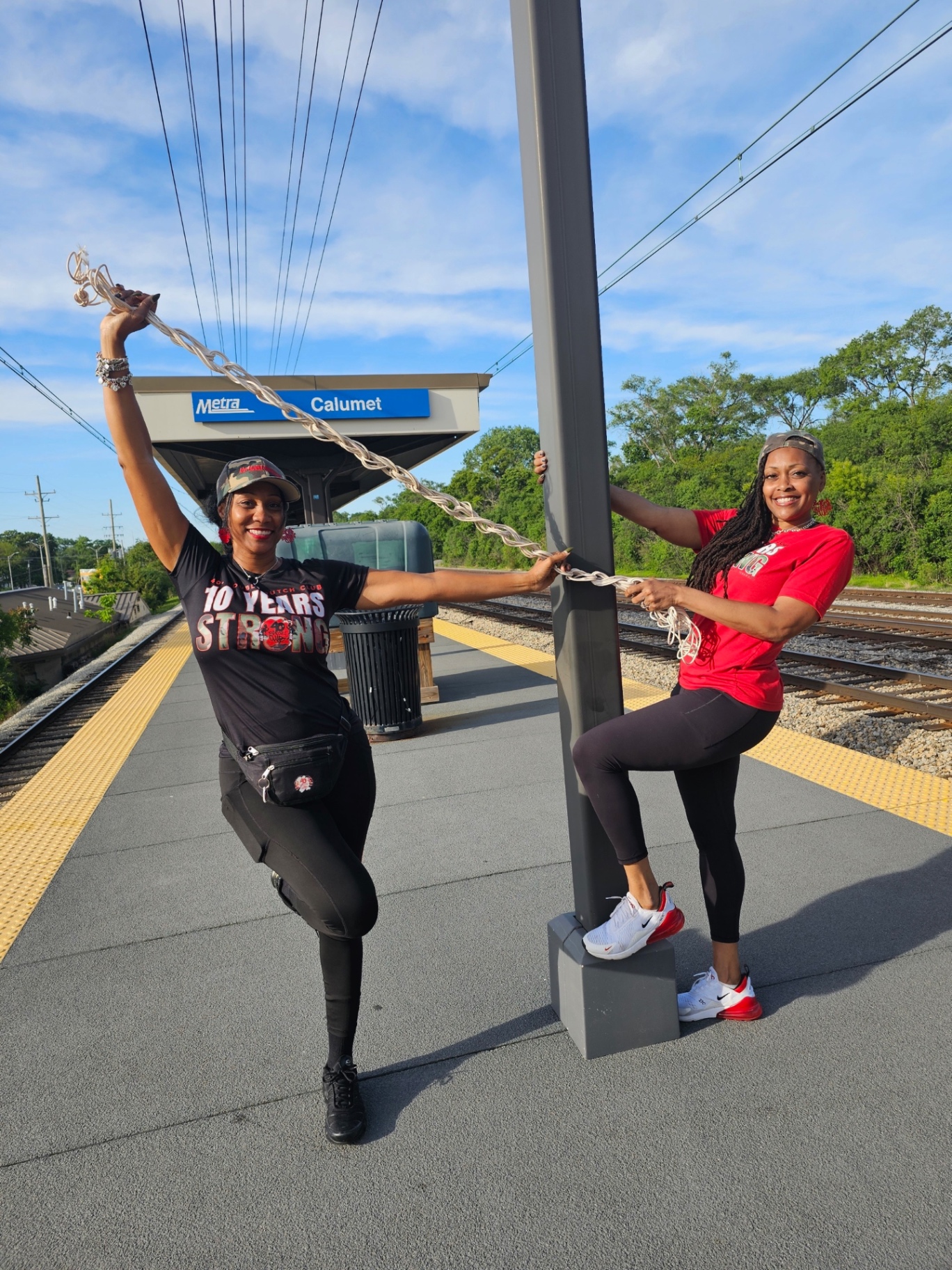 Two 40+ DDC members posing with double dutch ropes at the Metra Calumet station platform